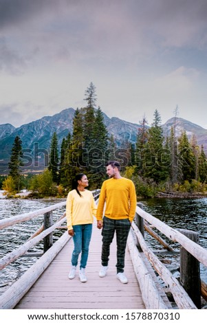 couple by the lake watching sunset, Pyramid lake Jasper during autumn in Alberta Canada, fall colors by the lake during sunset, Pyramid Island Jasper