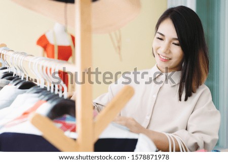 Smart beautiful Asian designer woman enjoy choose shopping cloth or shop owner business entrepreneur ideas concept