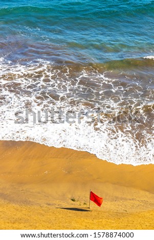 Red flag on the beach during the storm. Atlantic ocean coast, Las Palmas de Gran Canaria island, Canary islands, Spain