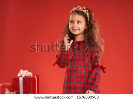 little girl surrounded by New Year's gifts 