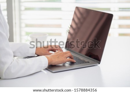 Businesswoman or accountant. Work in a creative and modern room.The laptop is on the table. A business person resting his hand on a laptop Working concept Business planning.