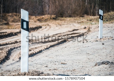 White road posts with notch on the road for cars