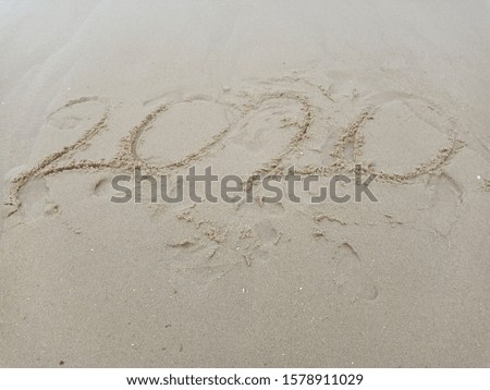 Happy New Year 2020 text on the sea beach. Abstract background photo of coming New Year 2020 and leaving year of 2019