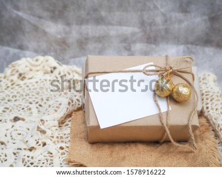 Vintage gift style rustic brown paper package tied up with strings. gift box on white fabric background.