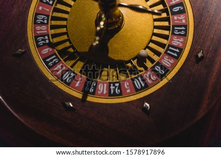Roulette table with chips in casino. Roulette wheel in the foreground. Gamble game. 