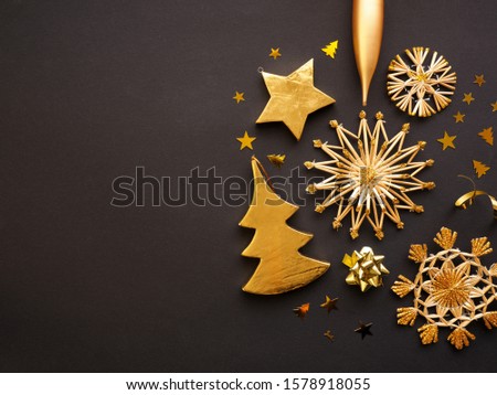 Golden Christmas decoration on a dark paper background with space for text or image