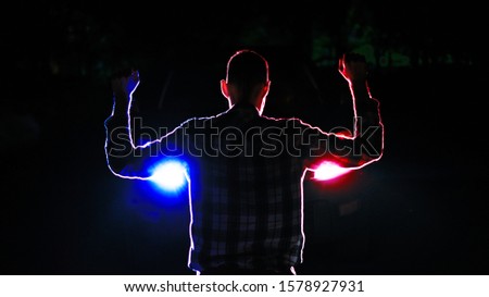 silhouette of  a male  criminal suspect with hands up during night pursuit in front of the police car headlights Royalty-Free Stock Photo #1578927931