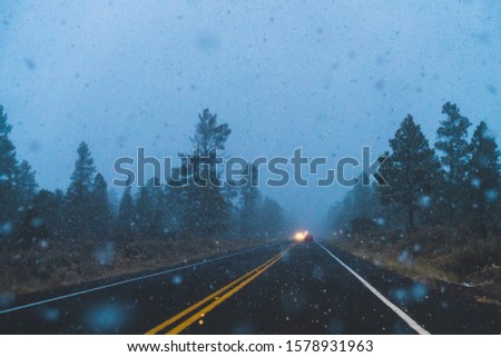 winter driving with snowing at dusk.