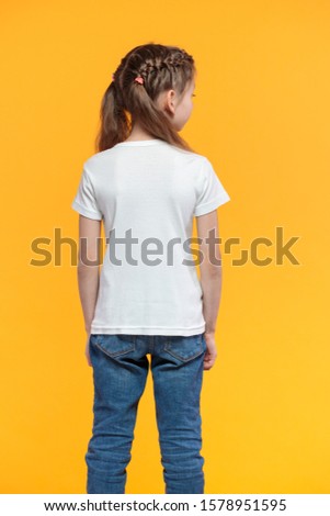 Kid girl wearing white t-shirt with space for your logo or design over yellow texture