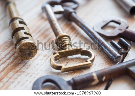 Old antique keys on a white wooden background