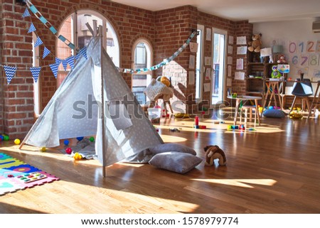 Picture of preschool playroom with colorful furniture and toys around empty kindergarten