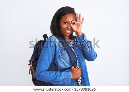 Young african american student woman wearing backpack over isolated background with happy face smiling doing ok sign with hand on eye looking through fingers