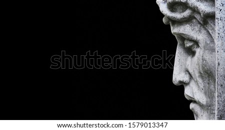 Close up ancient statue of Jesus Christ against black background