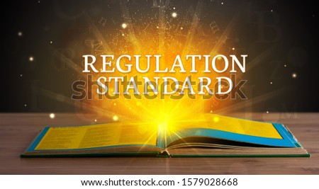 REGULATION STANDARD inscription coming out from an open book, educational concept
