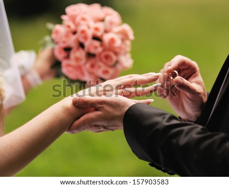 Marry me. Groom put a ring on finger of his lovely wife. Wedding couple together. Royalty-Free Stock Photo #157903583