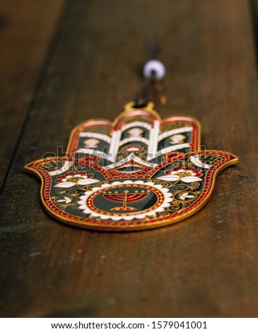protective amulet Hamsa Fatima hand with a beautiful pattern hanging on a rough wooden door