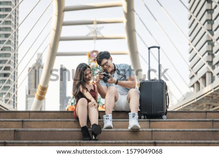 Young couple with travel bag looking picture on camera. Couple, Love, Valentine, Travel technology, gadget and Summer concepts.