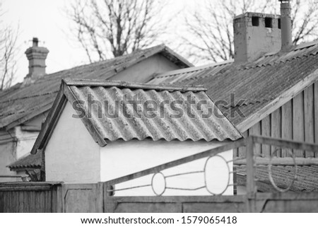 Rural old roofs covered with corrugated asbestos cement sheet, bw photo