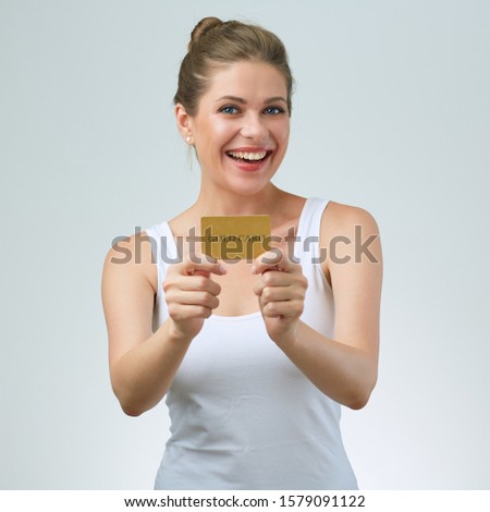 happy woman in white vest holding credit card in front of her. isolated female portrait.