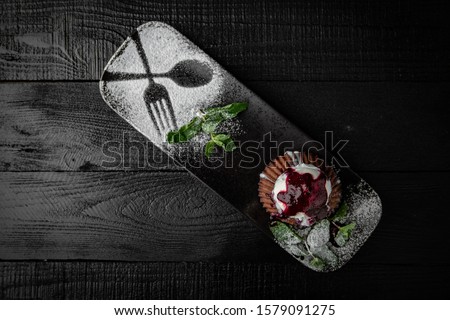 Dessert chocolate fondant with a scoop of ice cream and berry jam. Black boards background