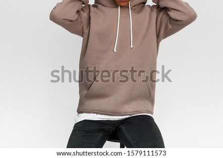 A guy in a brown hoodie sits on a chair