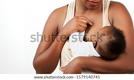 African young  Mother breastfeeding her little baby in her arms. Royalty-Free Stock Photo #1579140745