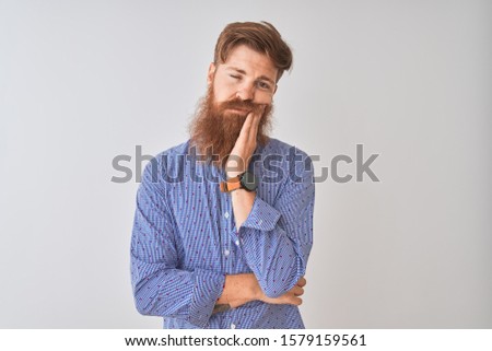 Young redhead irish man wearing casual shirt standing over isolated white background thinking looking tired and bored with depression problems with crossed arms.