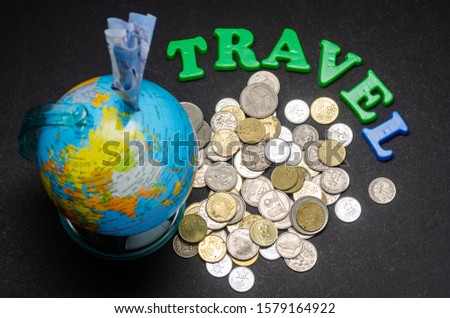 Concept photo of travel with piggy bank globe and Malaysian ringgit coins over the black background