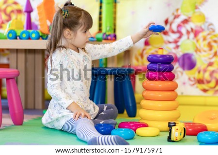 little girl playing in kindergarten or at home in the nursery