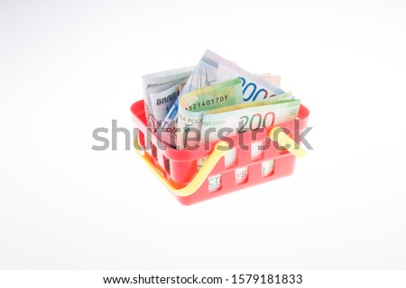 Supermarket cart with ruble banknotes on a white background