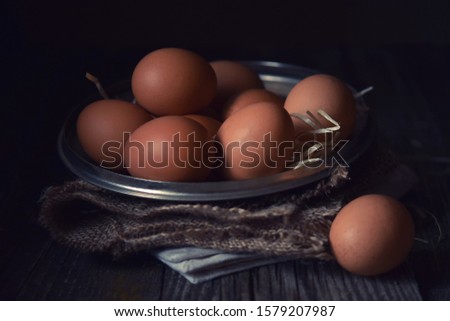 clean eggs in a metal bowl on a dark background. . Dark and moody picture. Low key. Rustic.  Close up, selective focus.