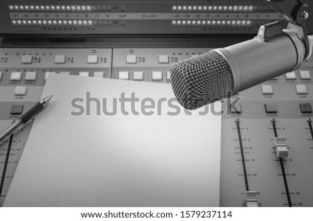 Professional microphone and sound mixer in radio station studio with blank paper and copy space