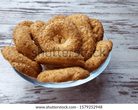 

Close-up of cookies, tasty, homemade, fresh, shortbread, sprinkled with sugar, in a glass plate on a background of abstract wooden surface