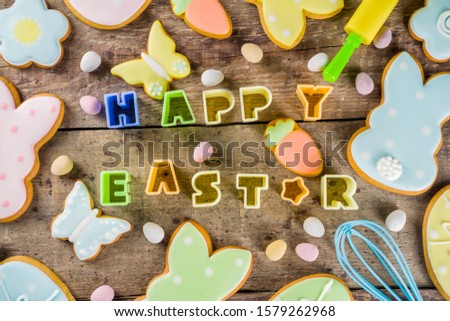 Happy easter background with pastel colored easter cookies - bunnies, eggs, flower, butterfly, Wooden rustic background, flatlay banner copy space