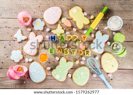 Happy easter background with pastel colored easter cookies - bunnies, eggs, flower, butterfly, Wooden rustic background, flatlay banner copy space