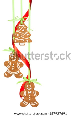 Gingerbread men and christmas tree cookies hanging by ribbon isolated on white.