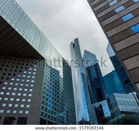 Skyscraper glass facades on a bright sunny day with sunbeams in the blue sky. Modern buildings in business district. Economy, finances, business activity concept. Bottom up view	