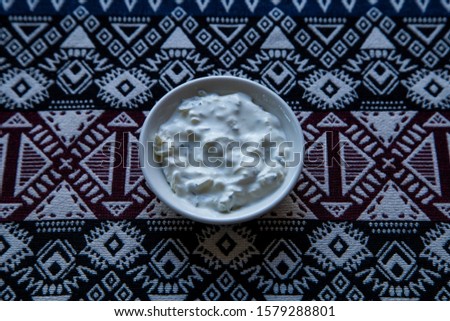 garlic sauce on a plate on a background of fabric with Asian ornament