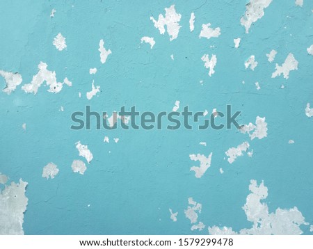 Exterior paint deteriorates on old cement floor. The concrete wall is dirty with peeling paint for graphic design or wallpaper. Vintage background in retro concept.