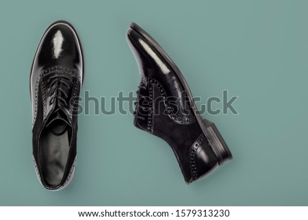 Black female patent shoes on dark green background. Fashion flat lay