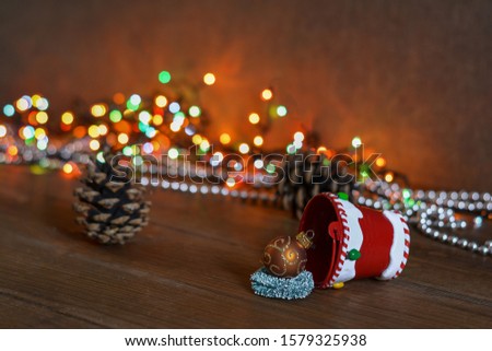 New Year card - a bucket of gifts on a wooden background, multi-colored garland. New Year and Christmas gifts.