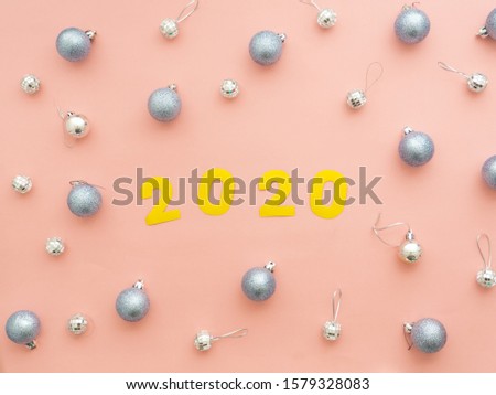 Silver Christmas balls on peach pink background. Festive Xmas decoration gray silver baubles. 2020 New Year
