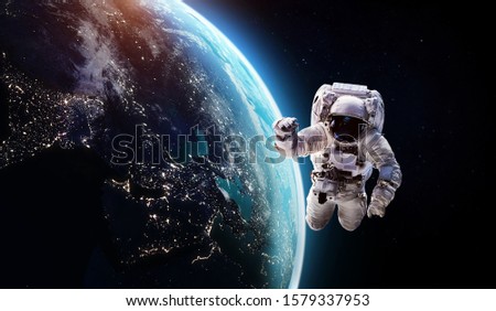 Astronaut in the outer space over the planet Earth. Abstract wallpaper. Spaceman. Elements of this image furnished by NASA
