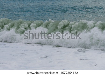 strong waves hitting the shore and bubbling