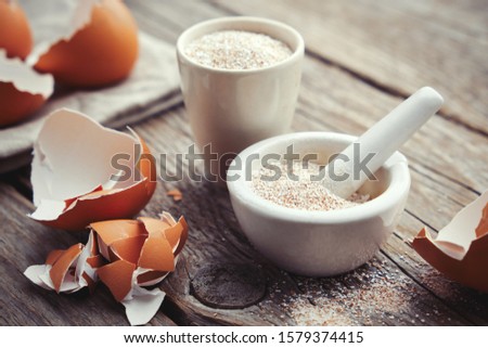 Mortar of crushed eggshell, whole and powdered eggshells, natural calcium, nutrient product. Royalty-Free Stock Photo #1579374415