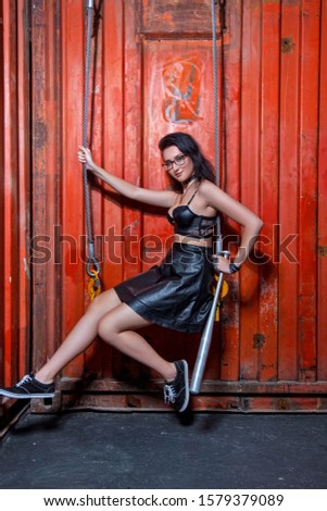 girl in leather skirt with a bat in the hangar