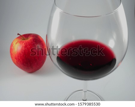 Glass of red wine and a red apple