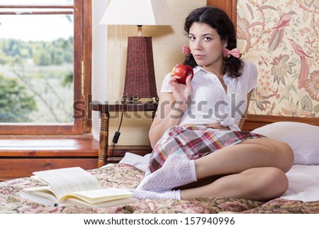 Woman in schoolgirl hold apple at one hand