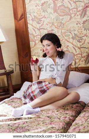 Woman in schoolgirl show eaten apple at bed