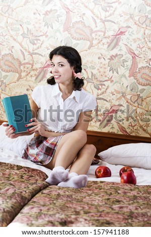 Happy woman in schoolgirl dress with mysterious book